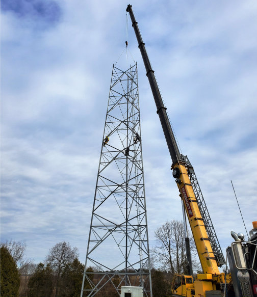 Yellow crane working on metal tower